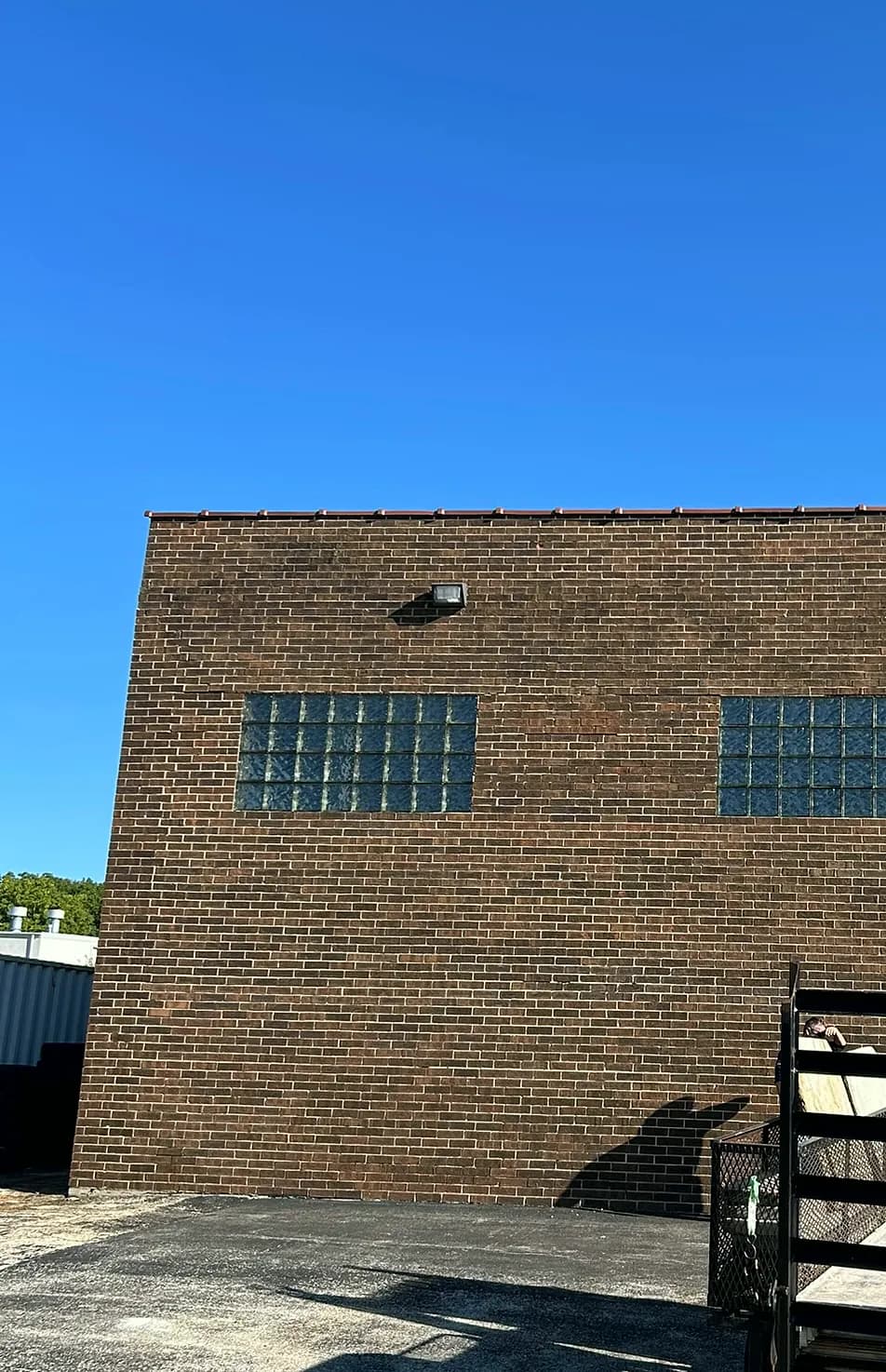 Tuckpointed commercial brick wall with restored glass-block window openings